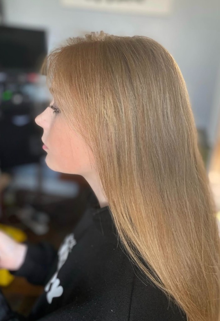 Straight honey blonde hair in profile