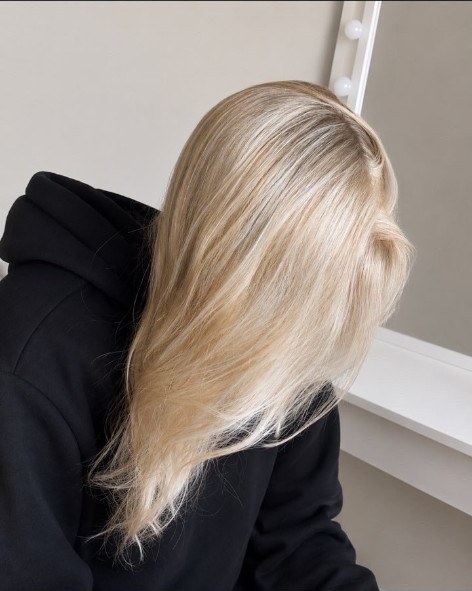 Pearly blonde hair with a soft side part