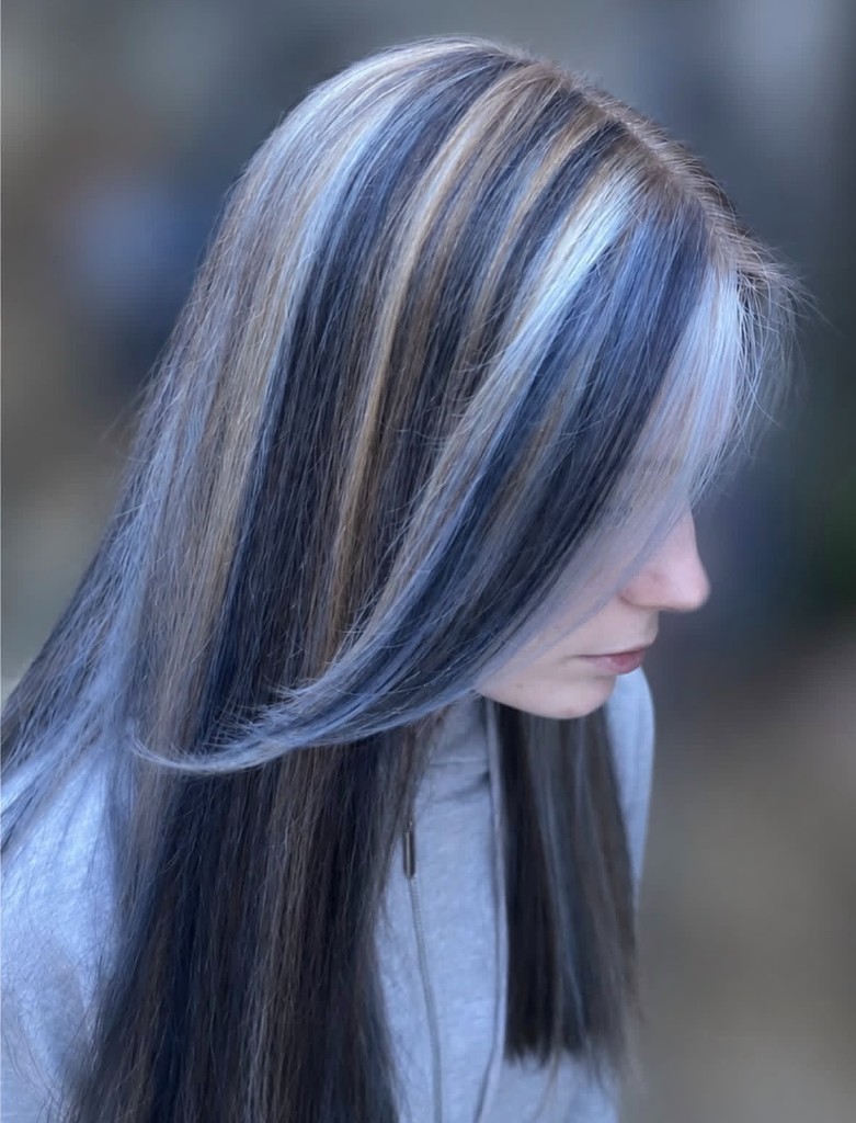 Dark hair with bright skunk-stripe highlights